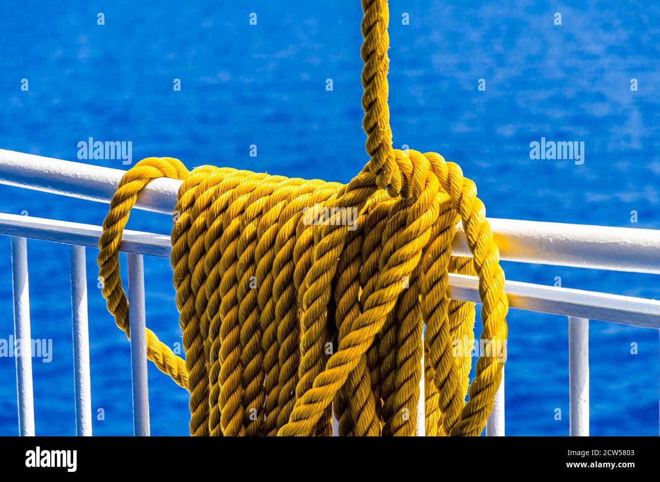 Yellow braided rope draped over a ship railing Stock Photo - Alamy
