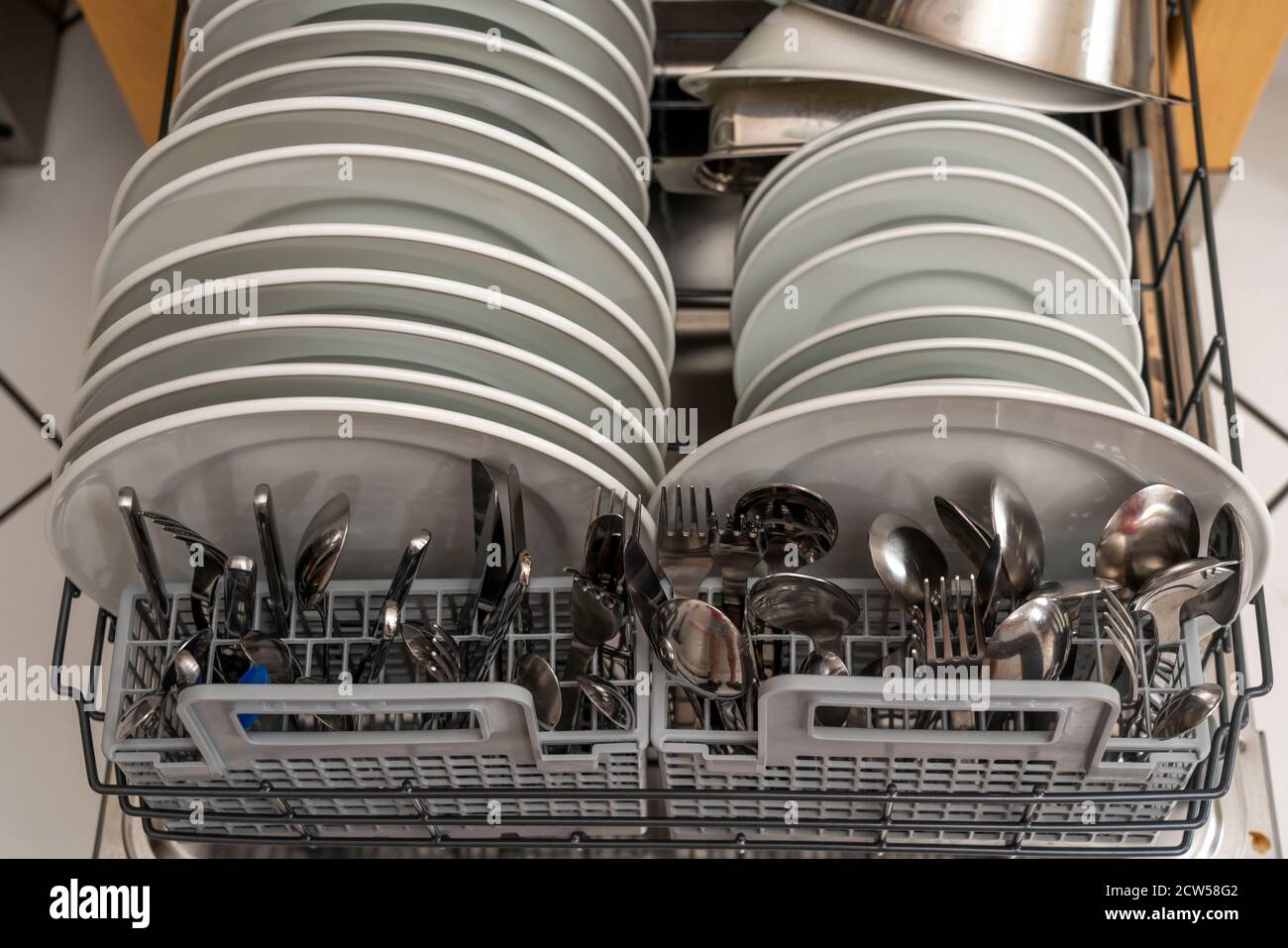 Dishwasher, full, with cleaned dishes, cutlery, cooking utensils Stock Photo Alamy