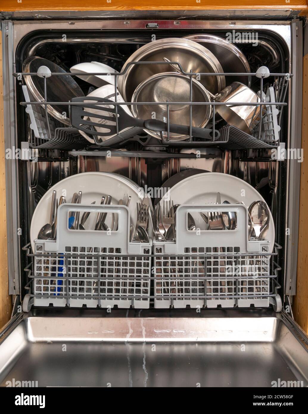 Dishwasher, full, with cleaned dishes, cutlery, cooking utensils Stock Photo Alamy