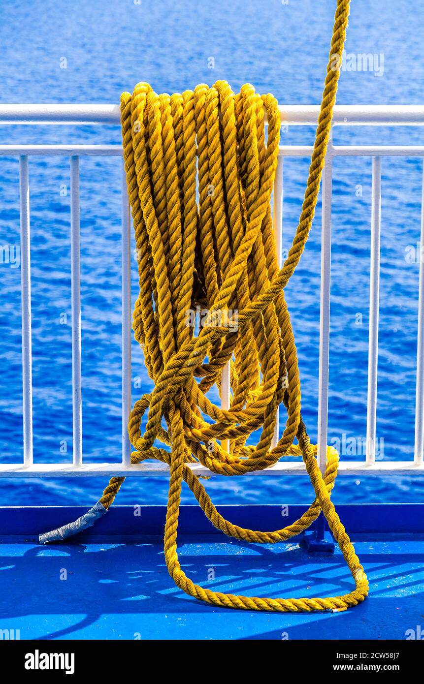Yellow braided rope draped over a ship railing Stock Photo - Alamy