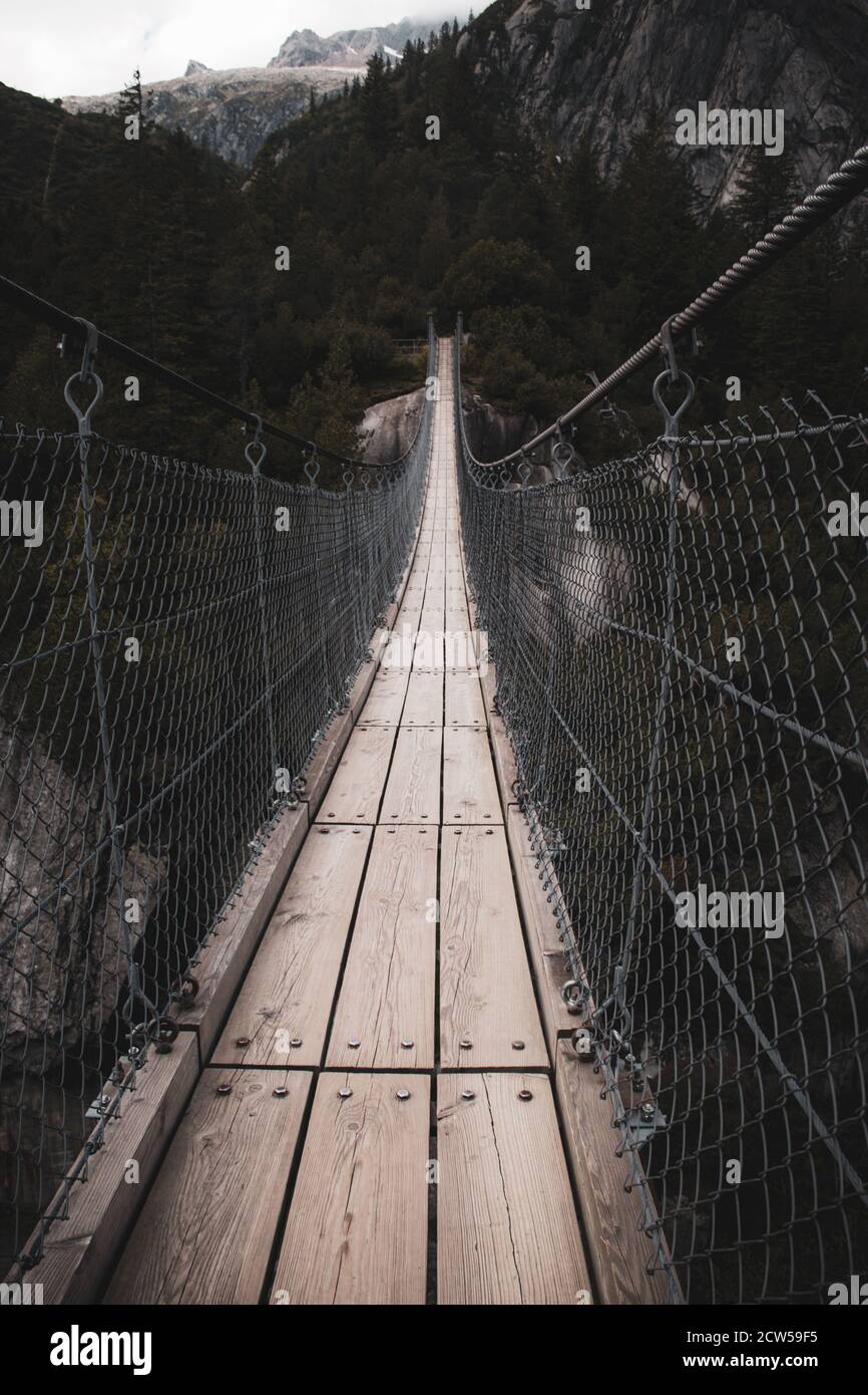 Suspension bridge hanging over river Stock Photo