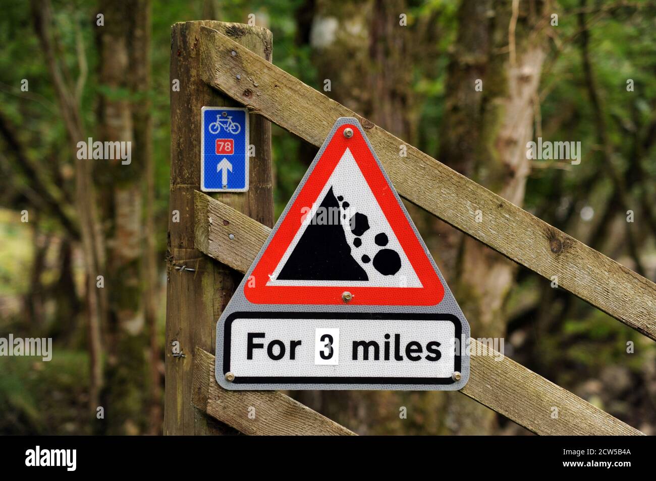 NATIONAL CYCLE ROUTE SIGN WITH FALLING ROCKS SIGN IN SCOTLAND NEAR FORT AUGUSTUS AND INVERNESS RE CYCLING HOLIDAYS FITNESS ETC UK Stock Photo