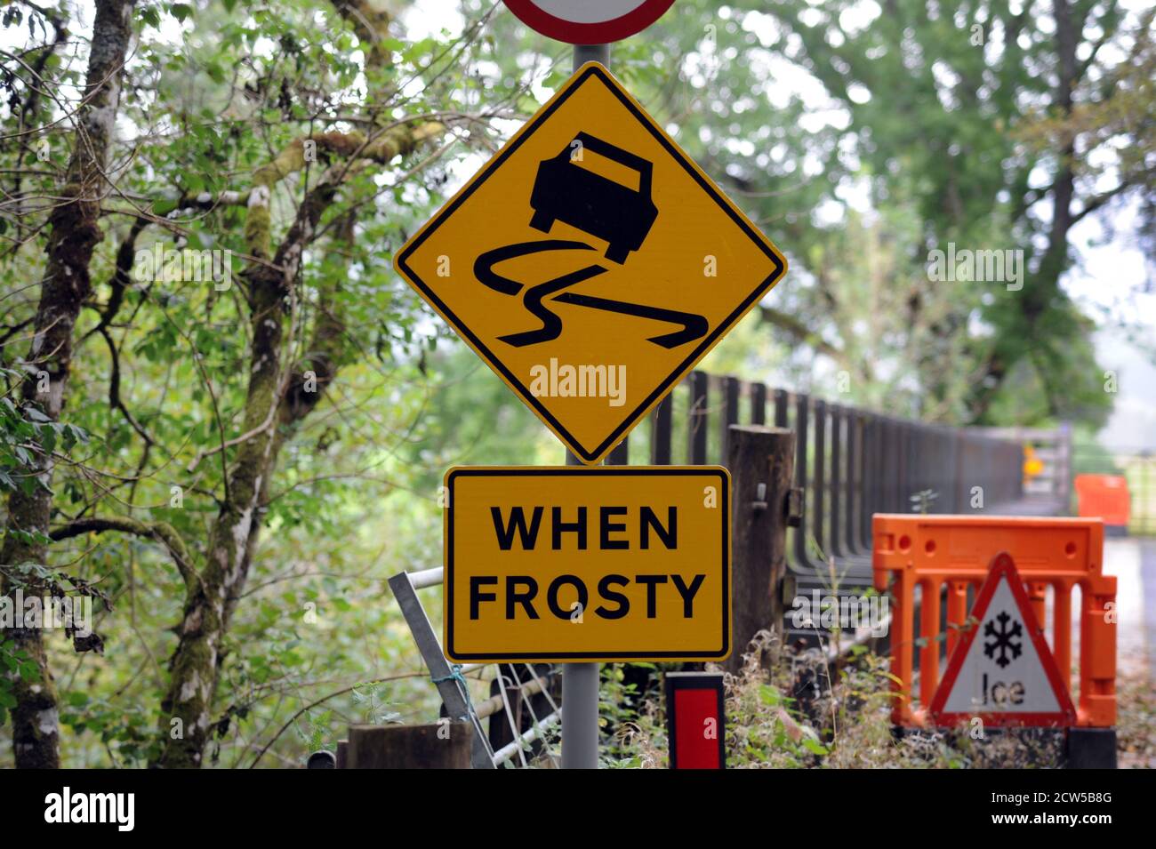 SLIPPERY ROAD WARNING SIGN RE CARS WINTER FROST SKID RISK WET ETC UK Stock Photo