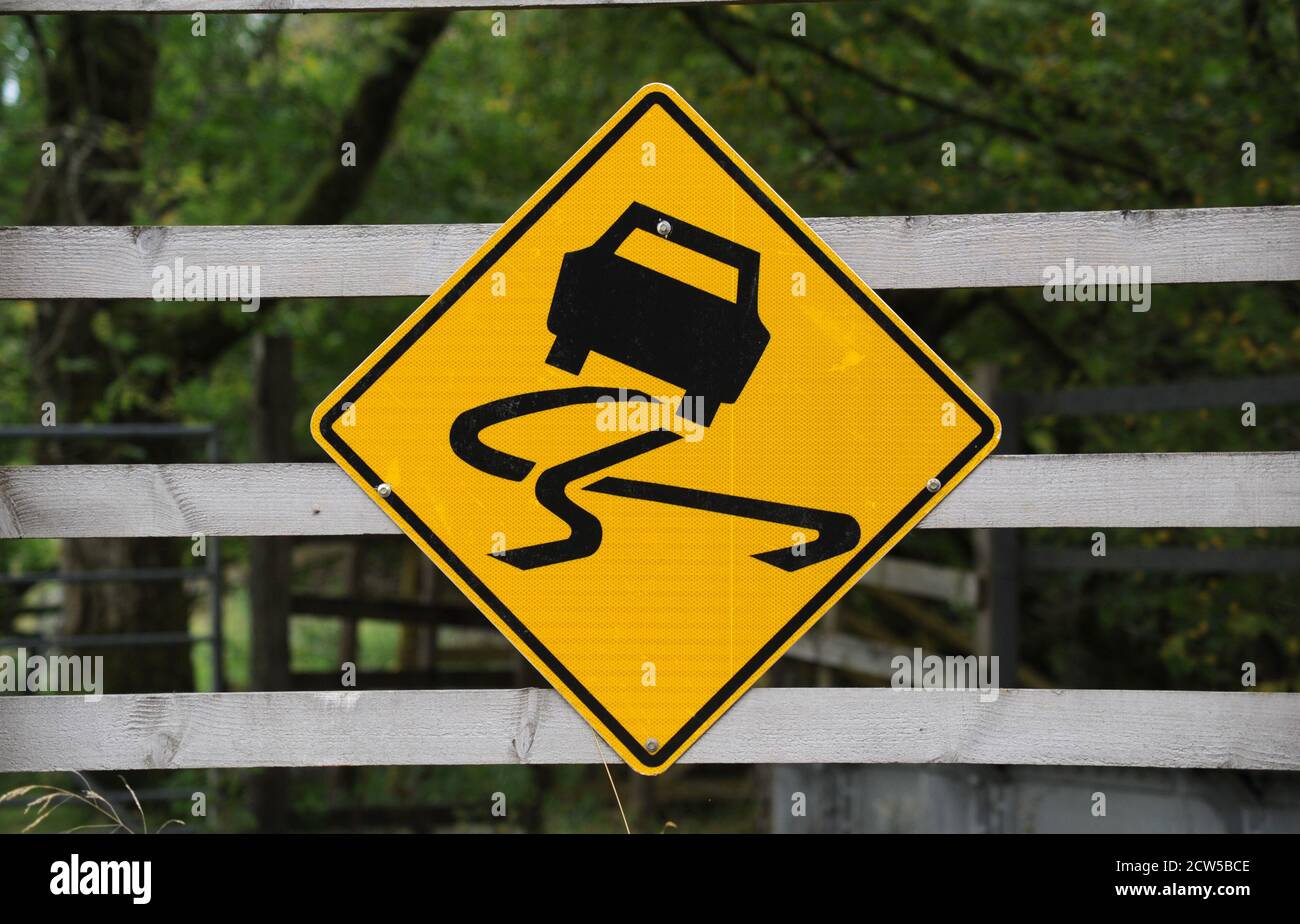 SLIPPERY ROAD WARNING SIGN RE CARS WINTER FROST SKID RISK WET ETC UK Stock Photo