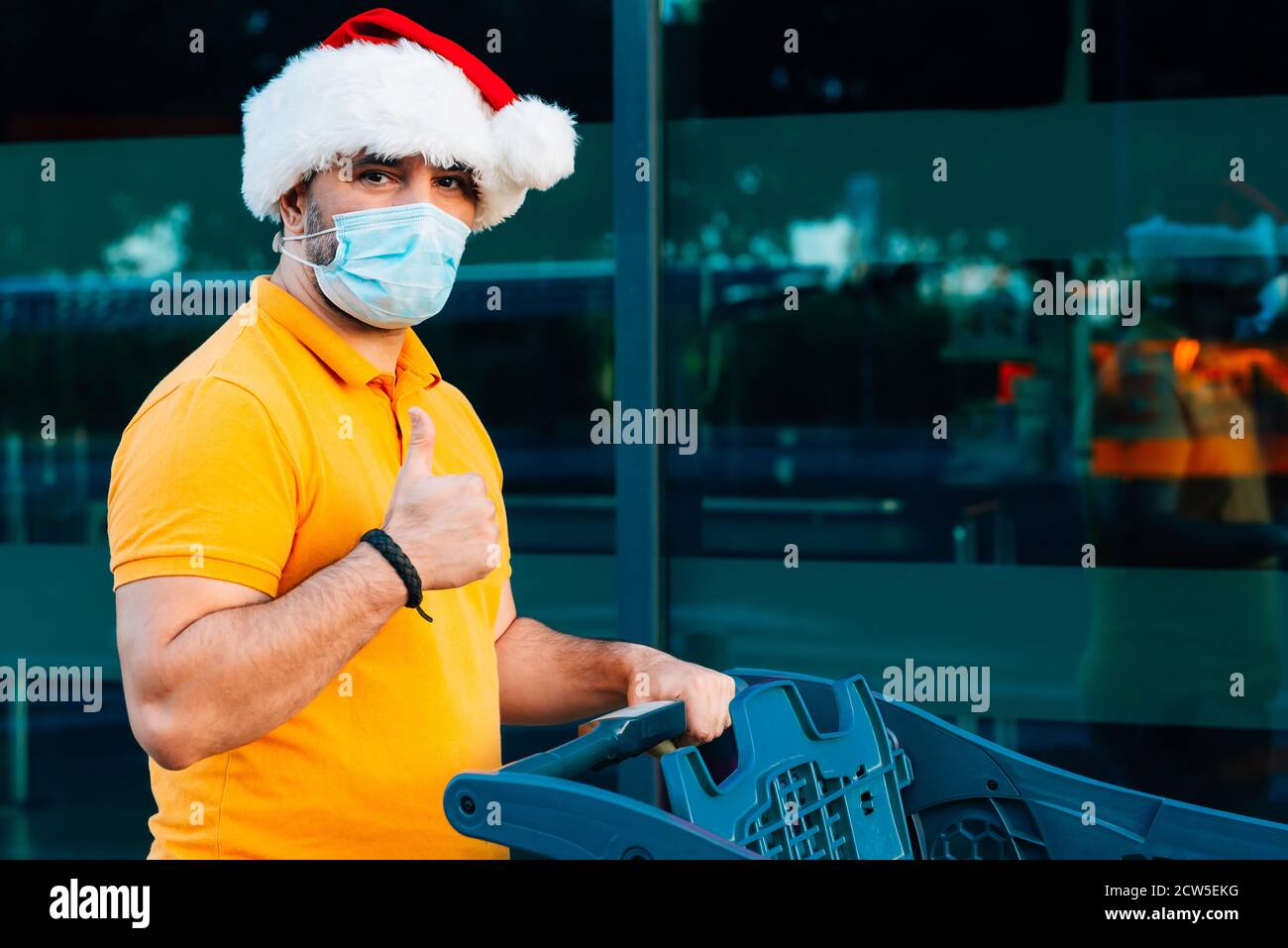 mature man with medical mask and christmas hat shopping Stock Photo