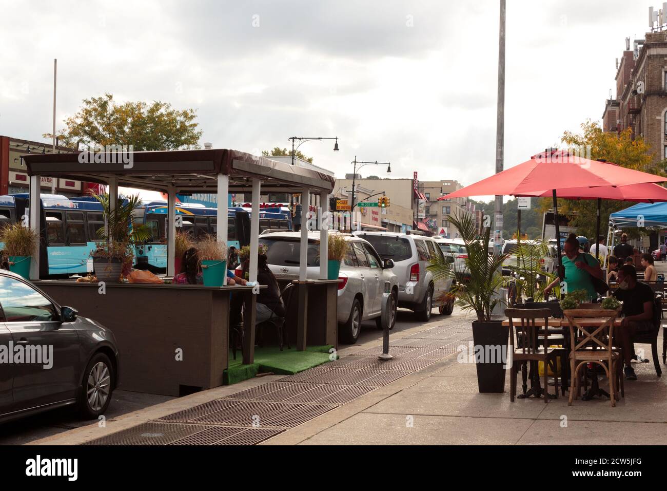 sidewalk dining tables and a dining booth in the street set up by the Garden Cafe restaurant to comply with covid-19 or coronavirus regulations in nyc Stock Photo