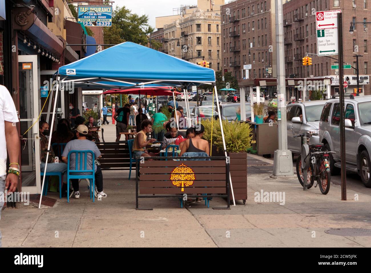 diners eating at outdoor sidewalk tables set up by a restaurant in Inwood, new york to comply with covid restrictions on restaurants Stock Photo