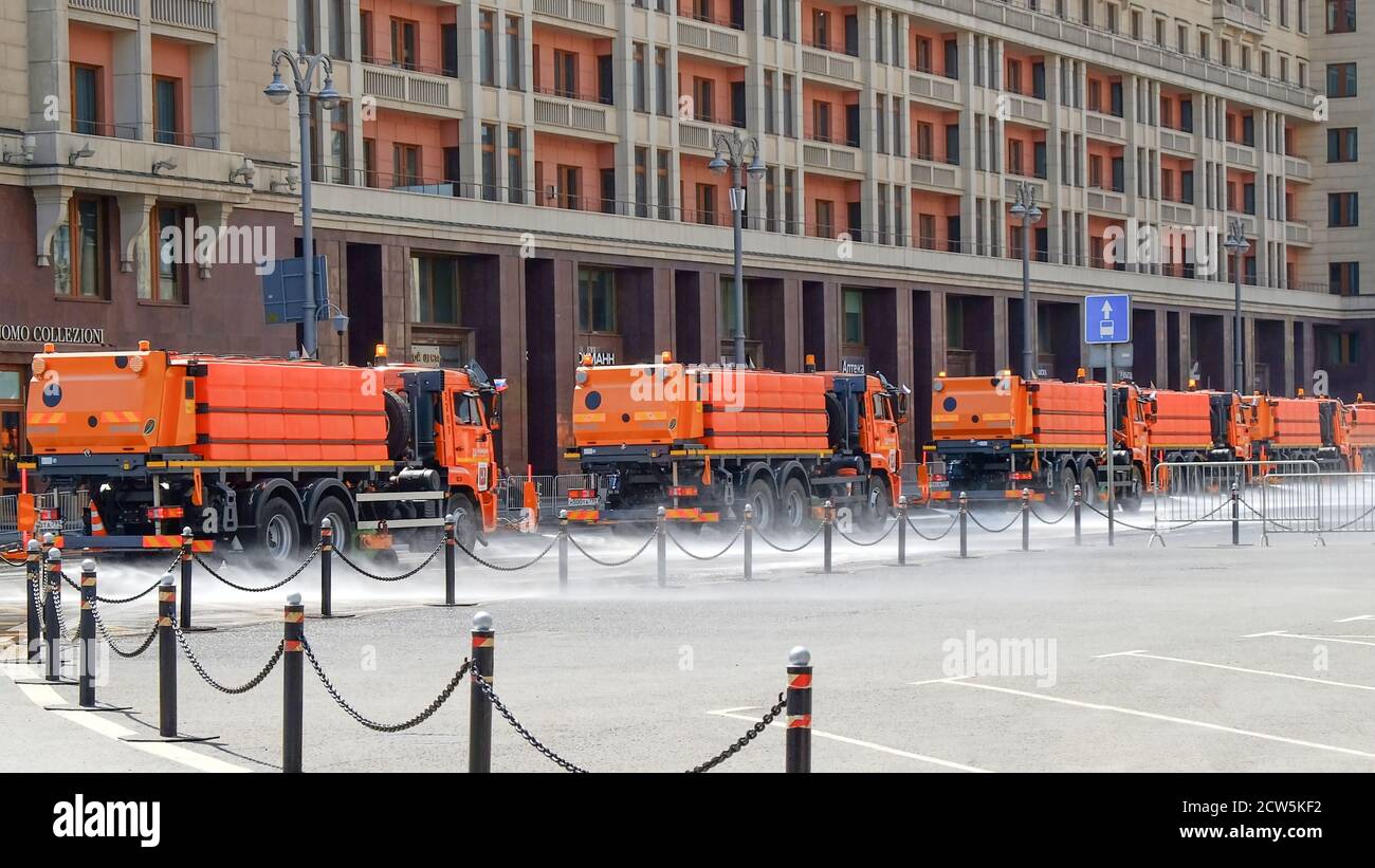 Column of municipal watering machines washes asphalt of city streets in the morning. Moscow,Russia,June 2020 Stock Photo