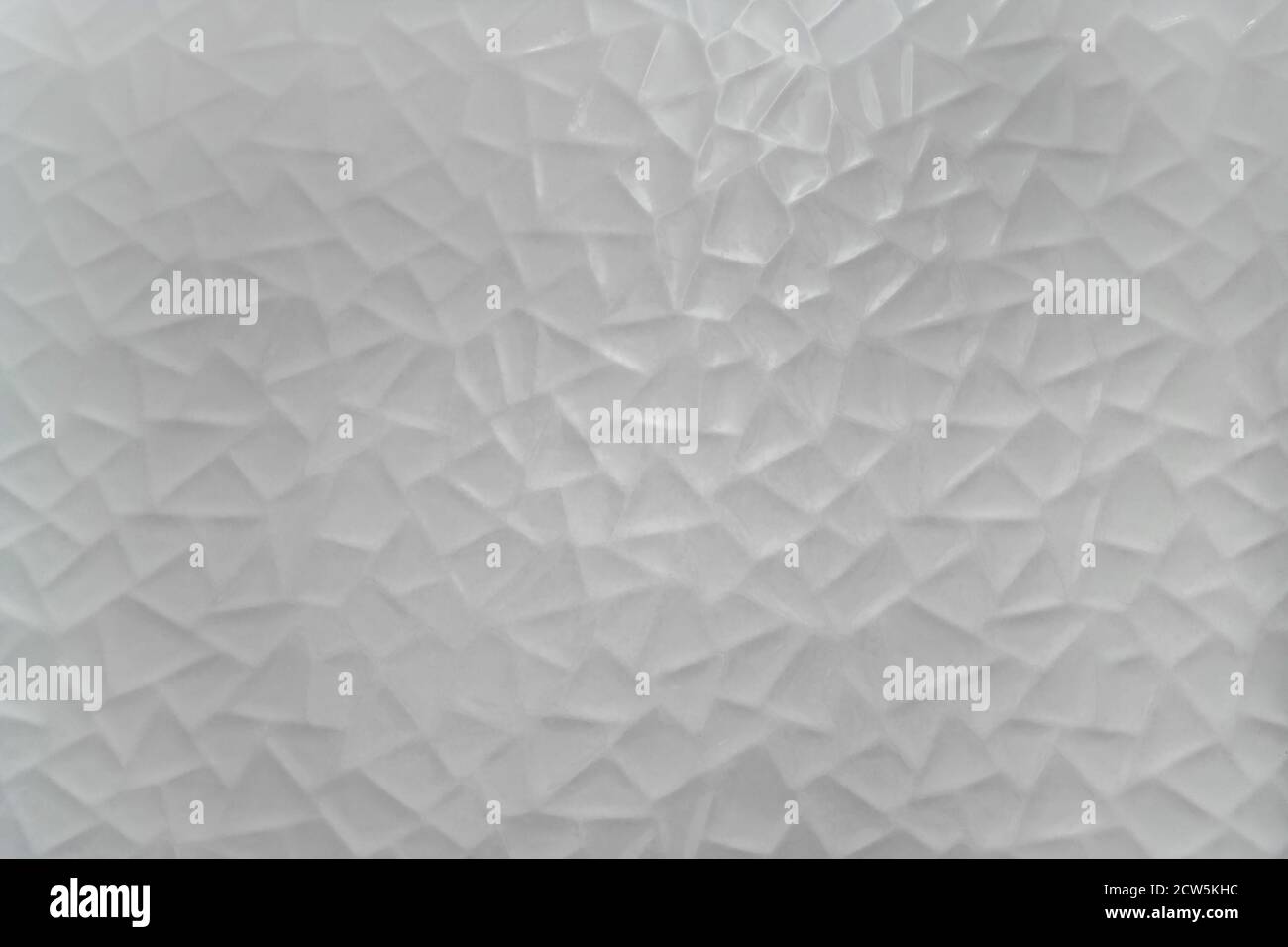 Background texture of a white ceramic wall with triangular goemetricals shapes. Stock Photo