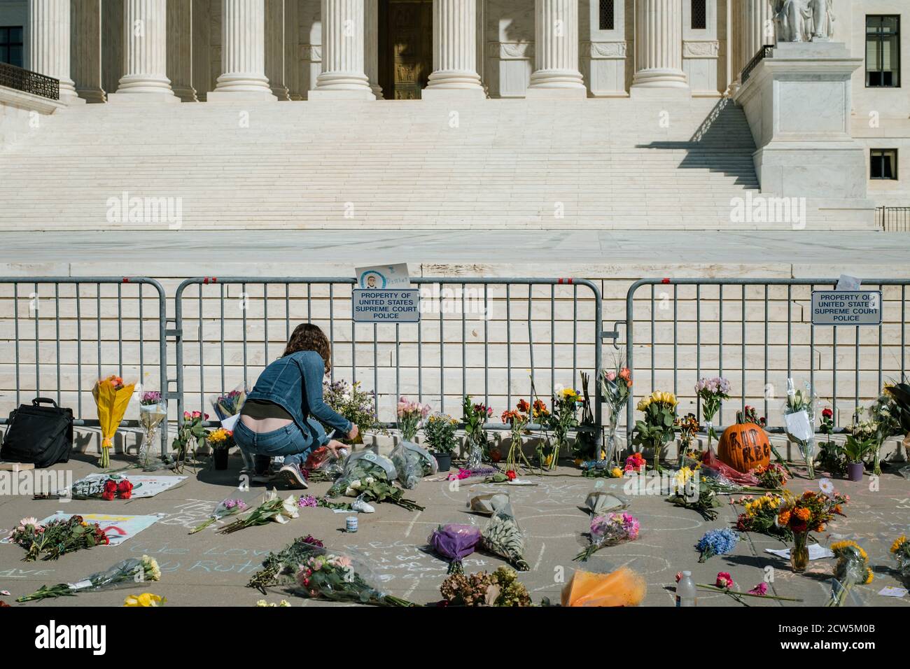 A woman lays flowers at the Supreme Court for Ruth Bader Ginsburg Stock Photo