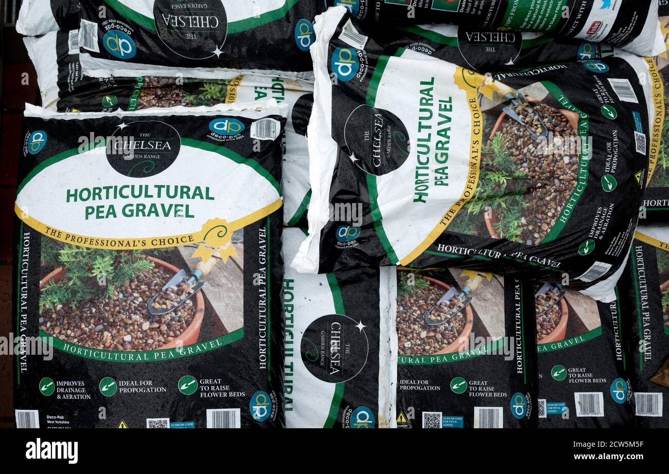 A stack of bags of Horticultural  pea  gravel for topping beds and pots in a garden centre Stock Photo