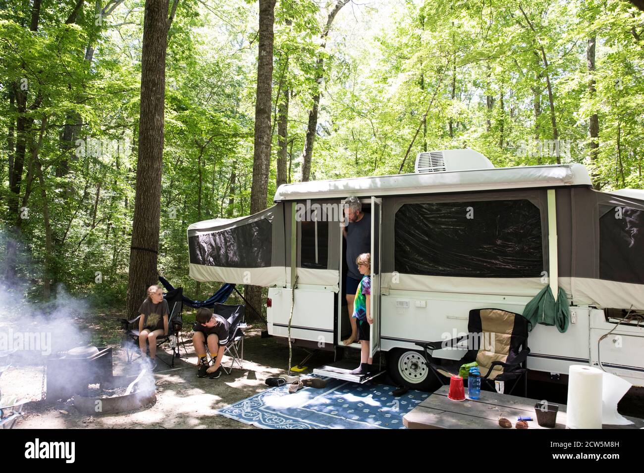 Wide View of Pop Up Camper at Campsite on Family Camping Trip Stock Photo