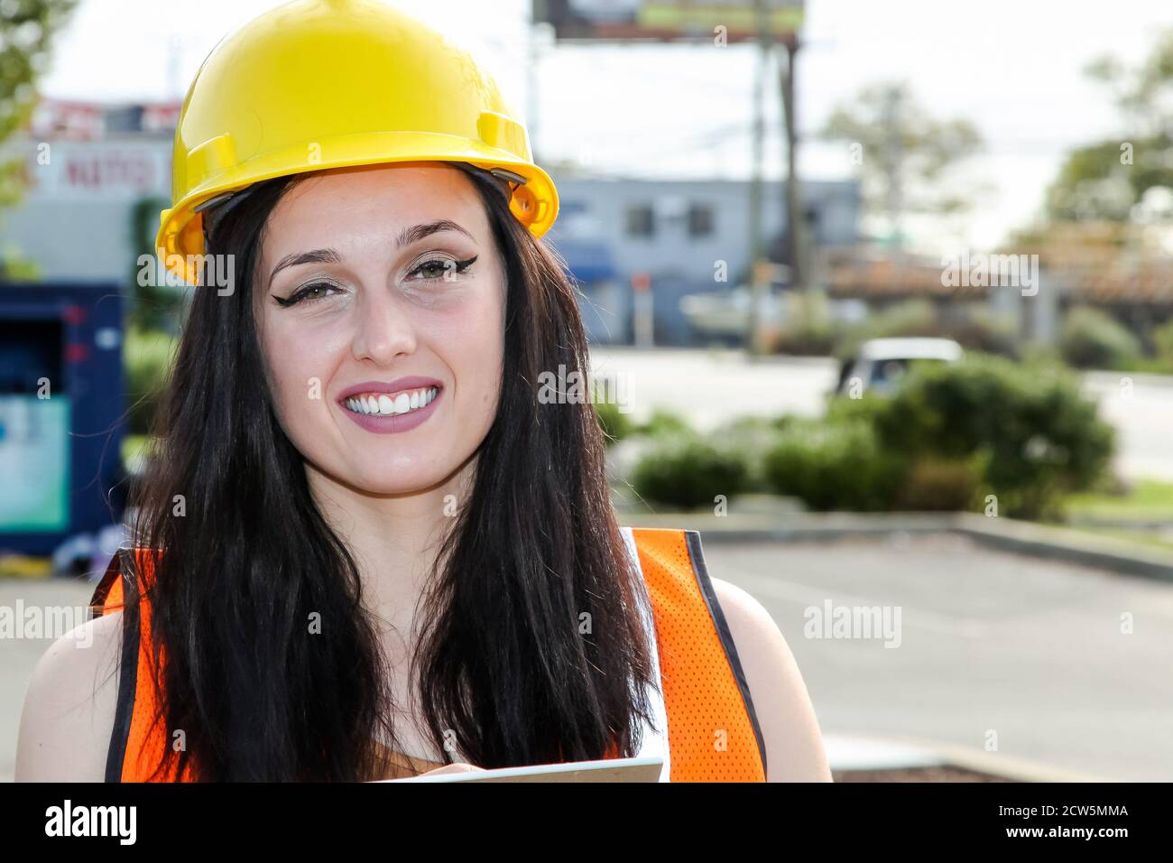 Pretty Young woman construction engineer with a protective yellow hard