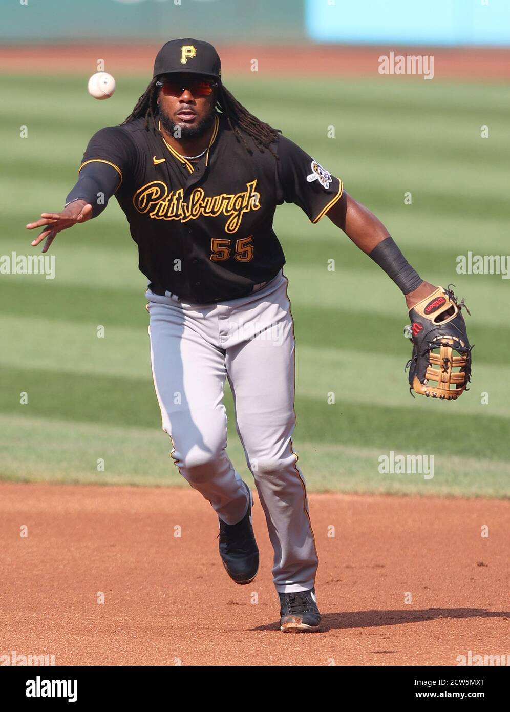 Pittsburgh Pirates first baseman Josh Bell (55) leaps for a high toss from  starting pitcher Chris Archer after fielding a ball hit by Cincinnati Reds'  Yasiel Puig (66) in the third inning
