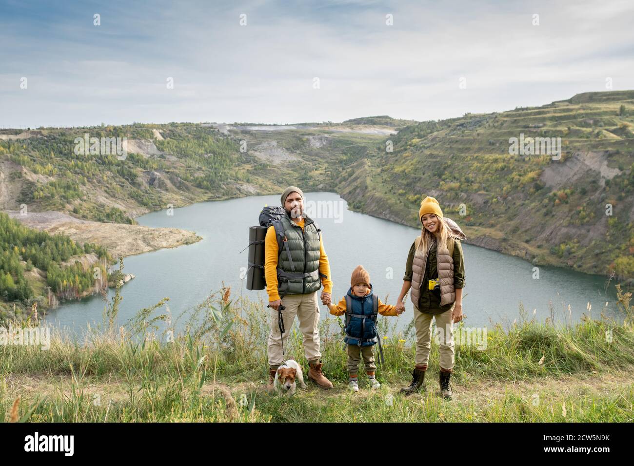 Happy family of young couple and their little son in warm casualwear having trip Stock Photo