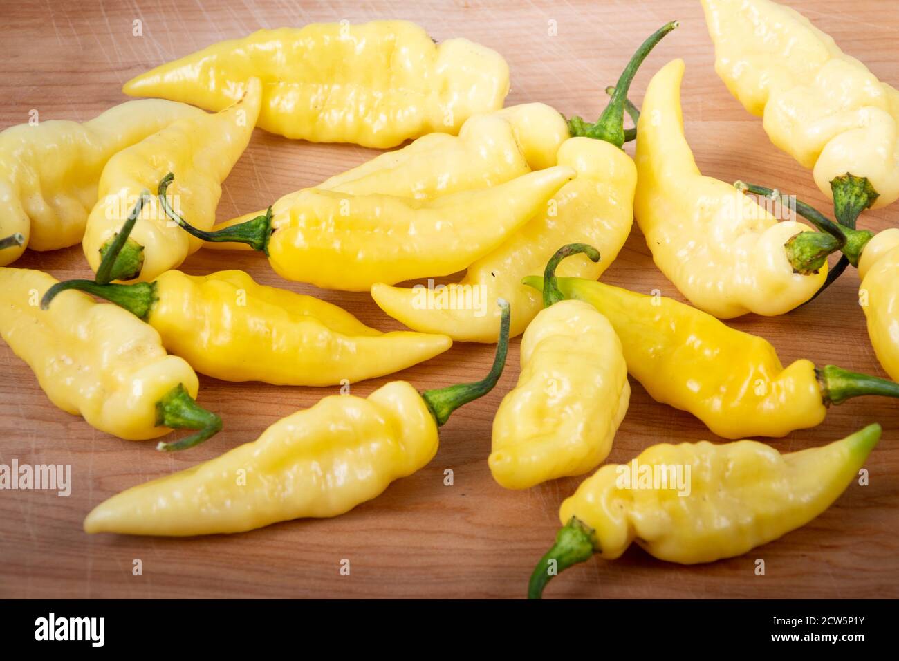 carbonero yellow hot pepper fruity chile pods over wood plank