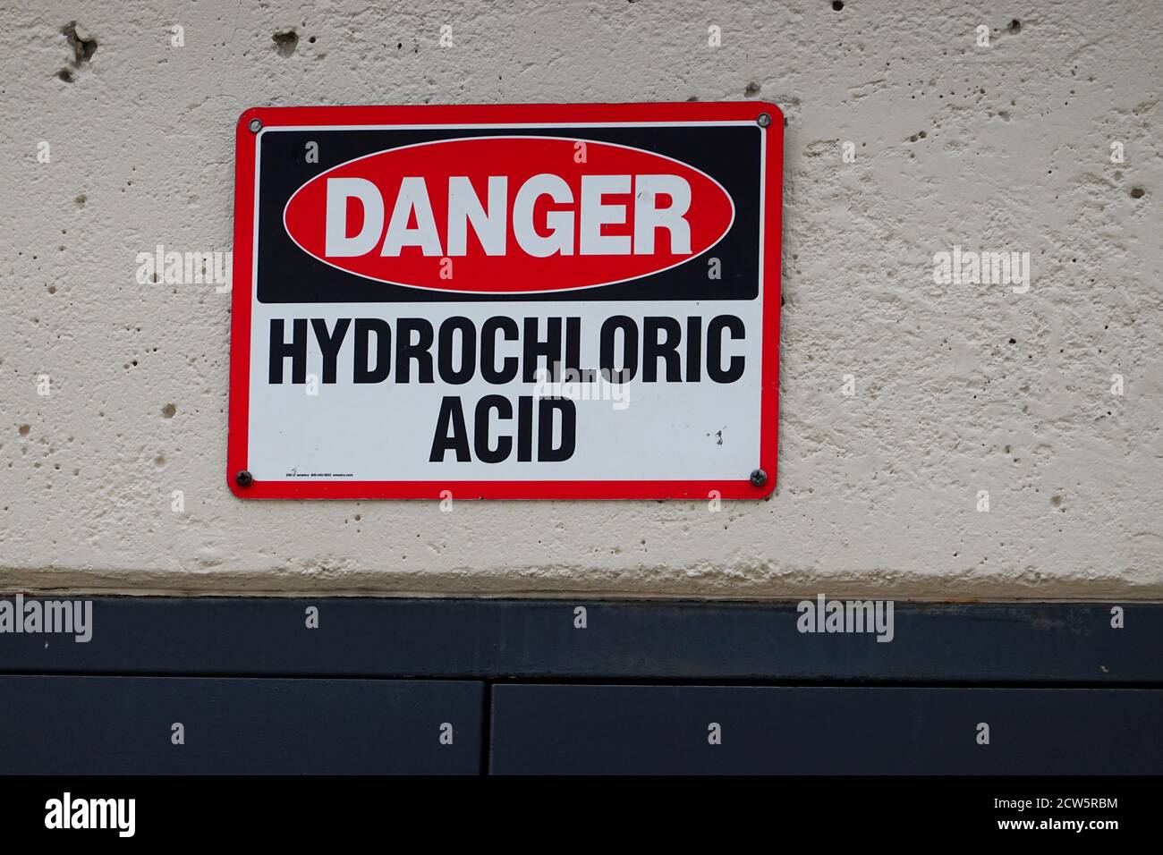 Danger Hydrochloric acid sign on a swimming pool wall Stock Photo