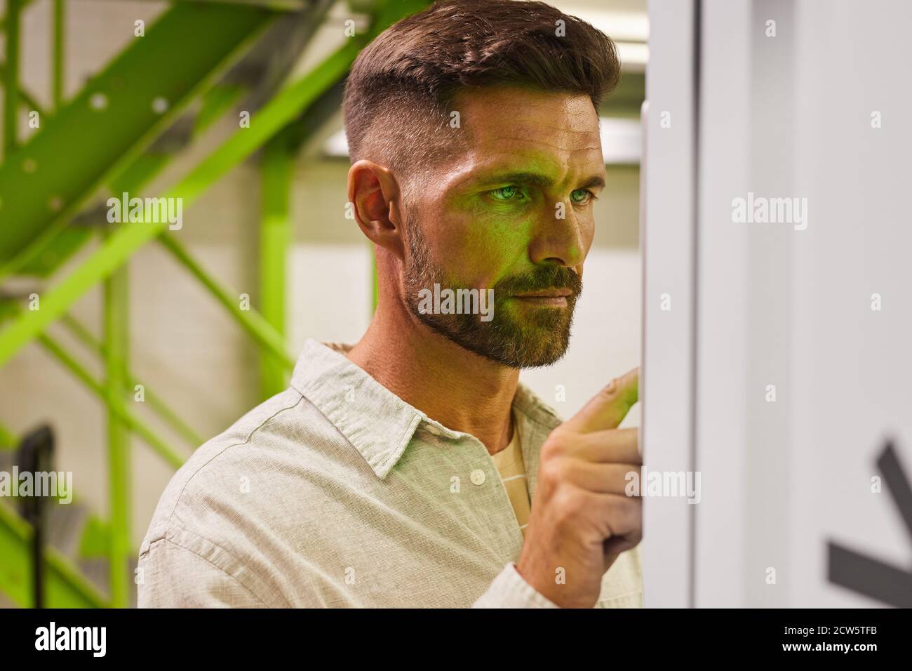 Portrait of handsome bearded man using control panel while operating self storage unit, copy space Stock Photo