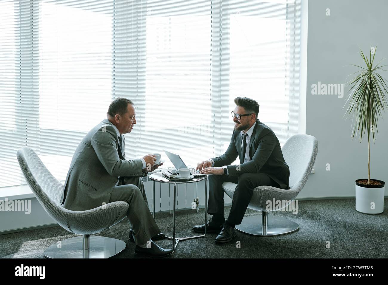Two confident mature businessmen in formalwear discussing working moments Stock Photo