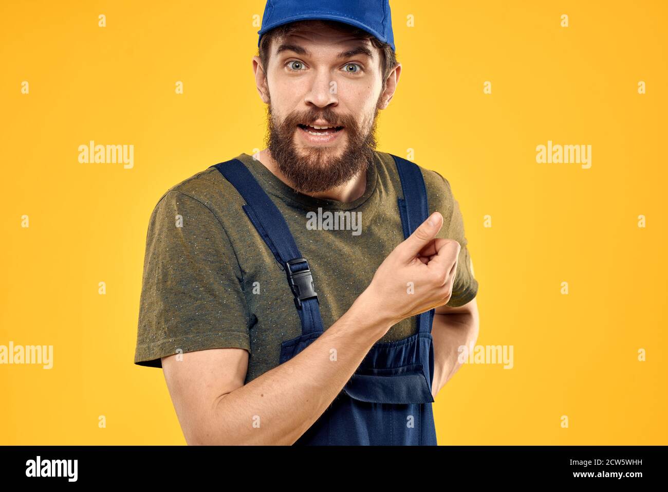 Worker man in uniform worker service yellow background emotion Stock