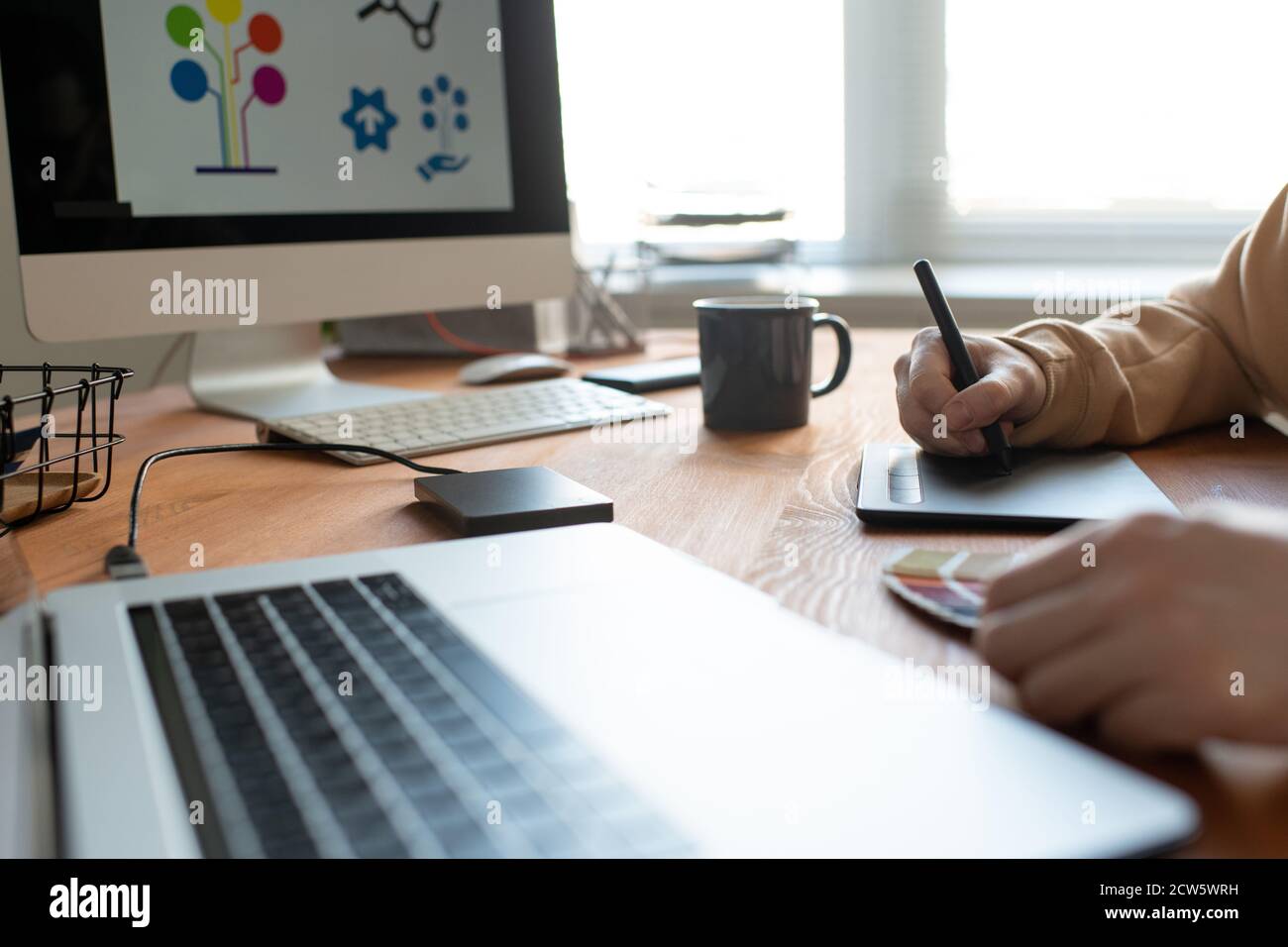 Hands of young creative freelance designer holding stylus over tablet screen Stock Photo