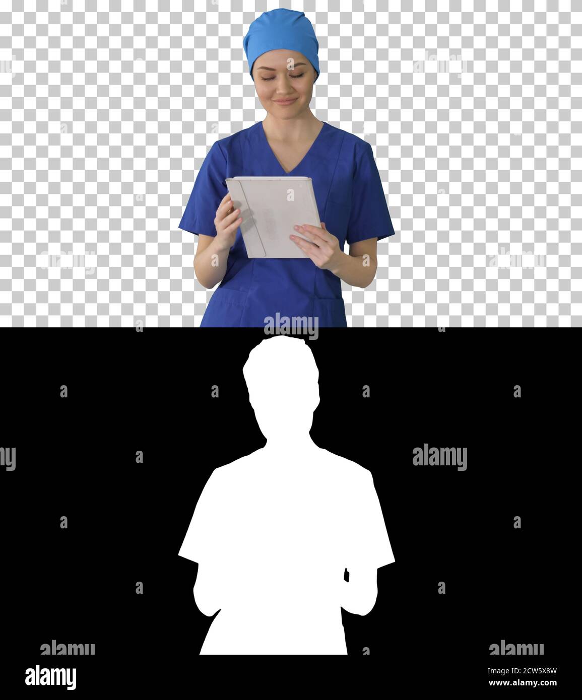 Smiling female nurse using tablet computer walking and looking a Stock Photo