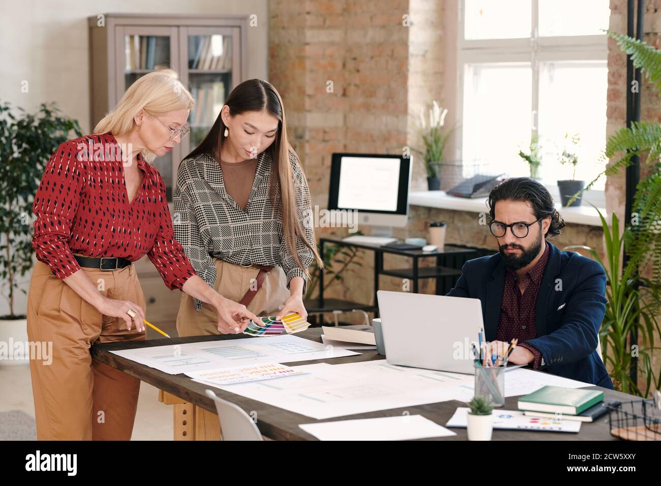 Two creative female designers choosing color for new mobile application Stock Photo