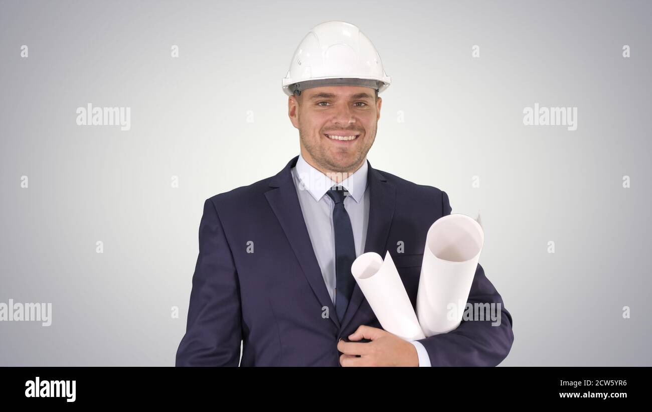 Smiling architect or engineer walking while keeping projects in Stock Photo