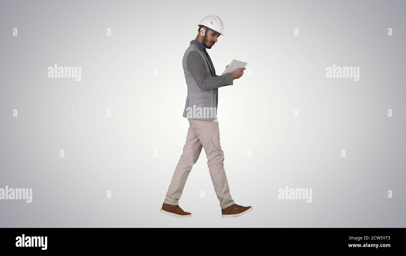 Engineer walking and working on digital tablet on gradient backg Stock Photo