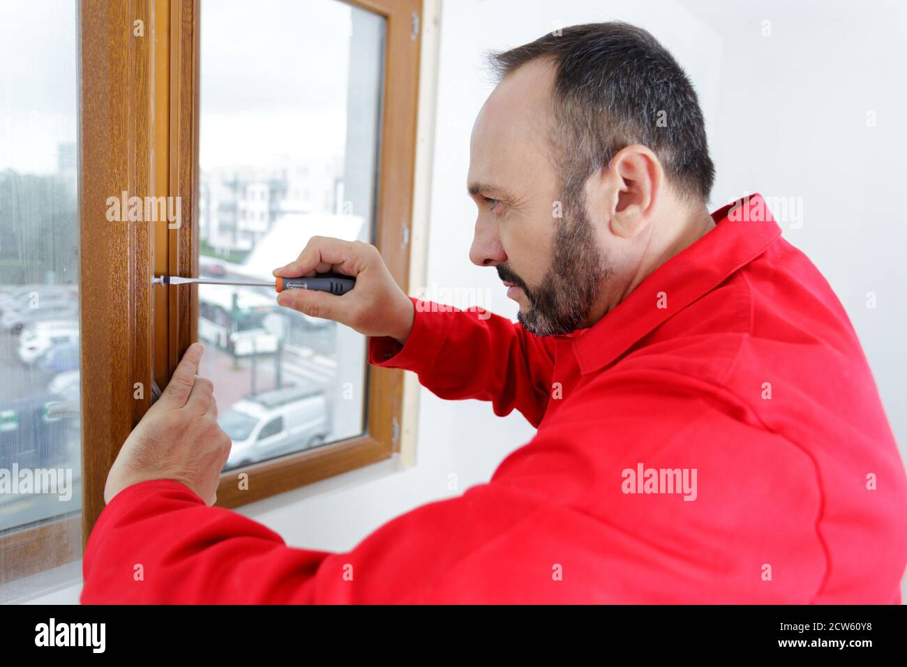 worker screwing into wooden window frame Stock Photo Alamy