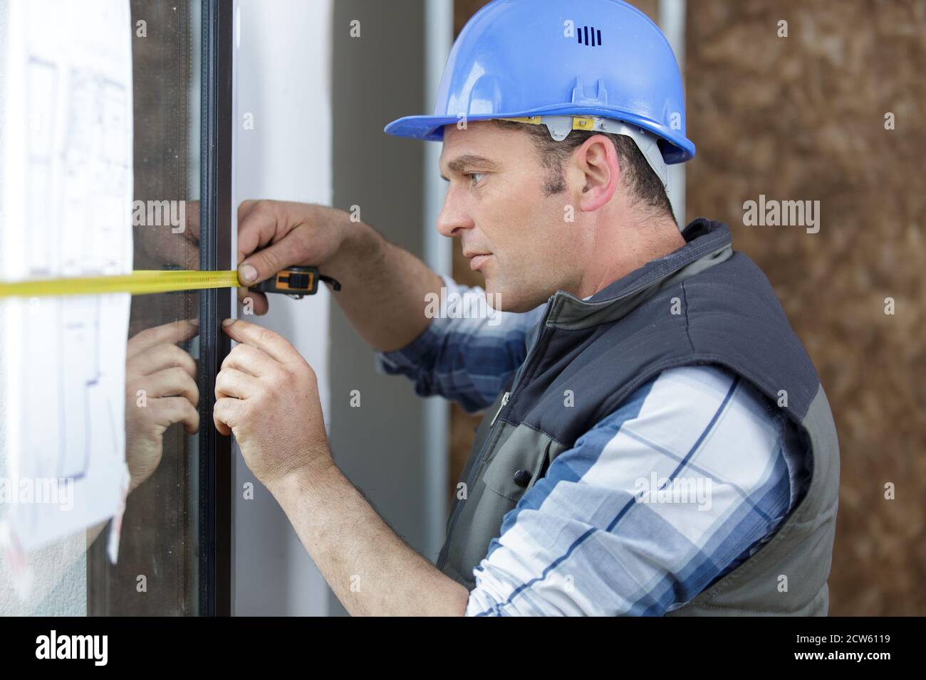 builders are installing measuring windows Stock Photo - Alamy