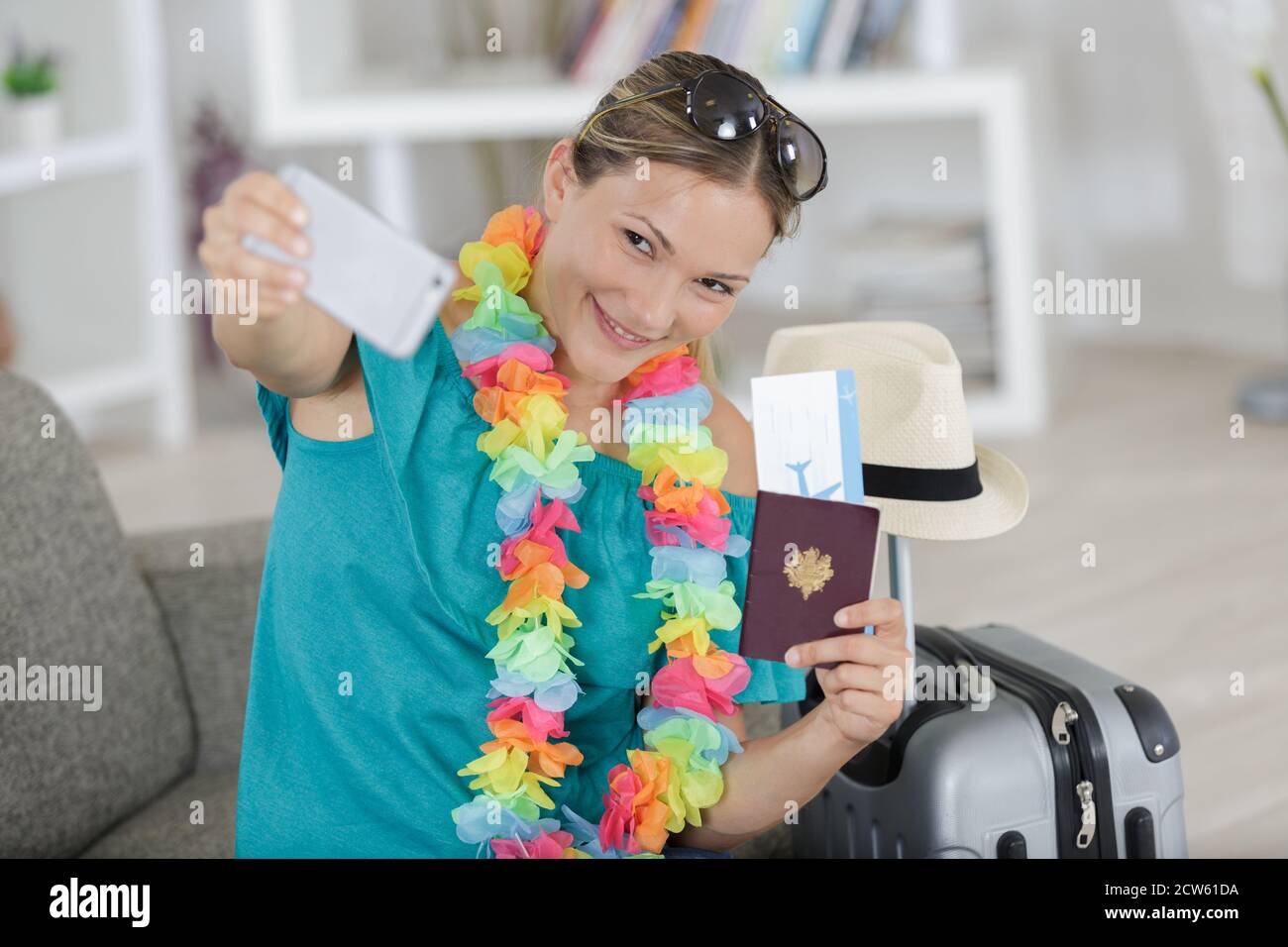 tourist girl in airport taking funny selfie with passport Stock Photo
