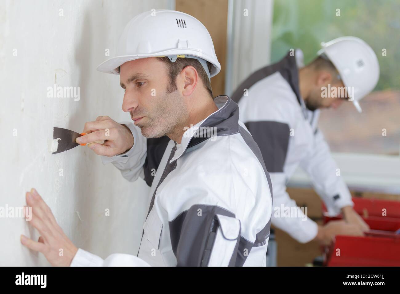 portrait of worker scraping the wall Stock Photo