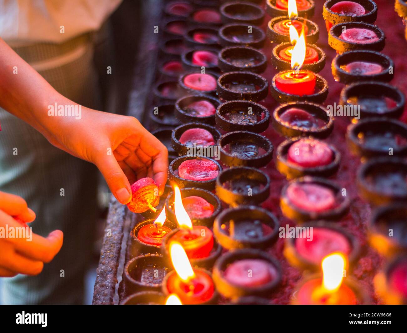A person lighting a candle at the Basilica del Sto Nino to pray Stock