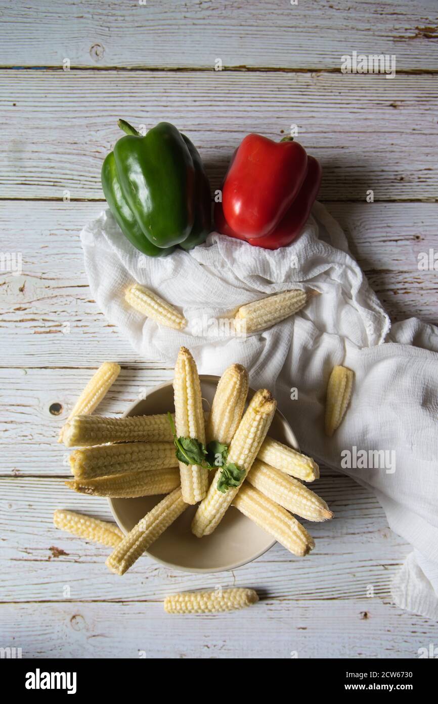Healthy fresh baby corns with bell peppers on a background Stock Photo