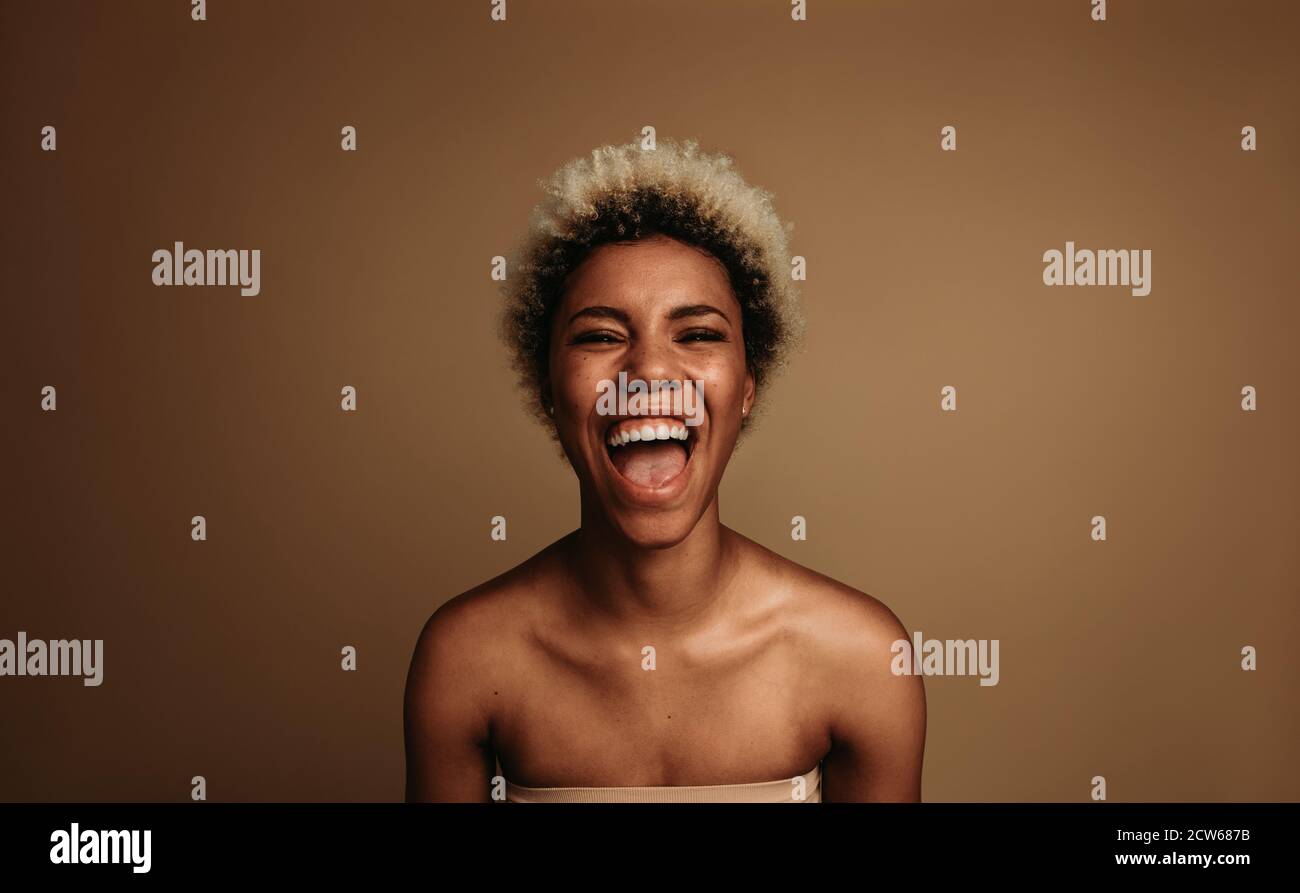 Close up of laughing african american woman. Portrait of happy curly haired woman. Stock Photo