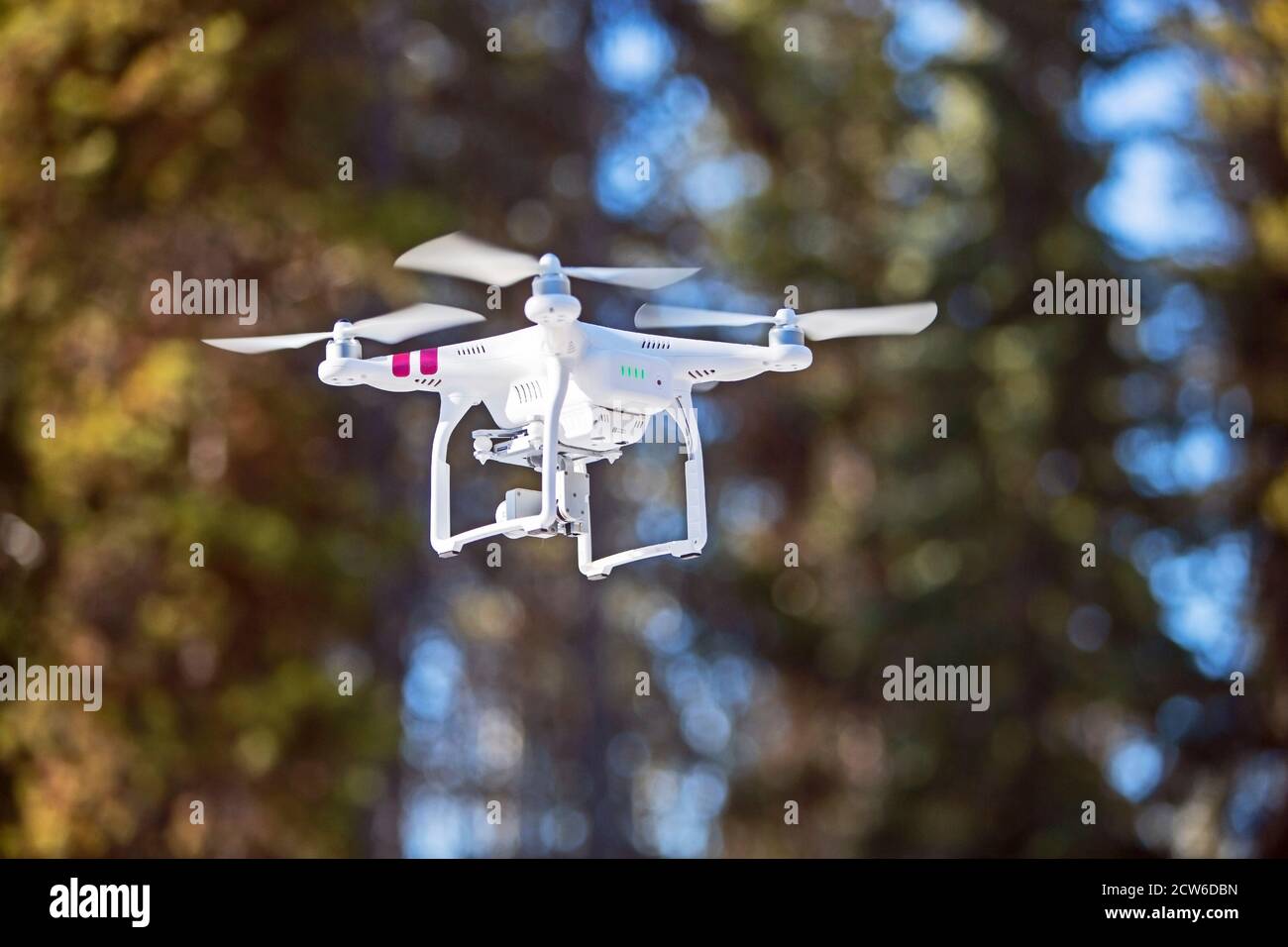 Quadro-copter, flying a long forest, recording video footage of the forest. blurred background, bokeh, Stock Photo