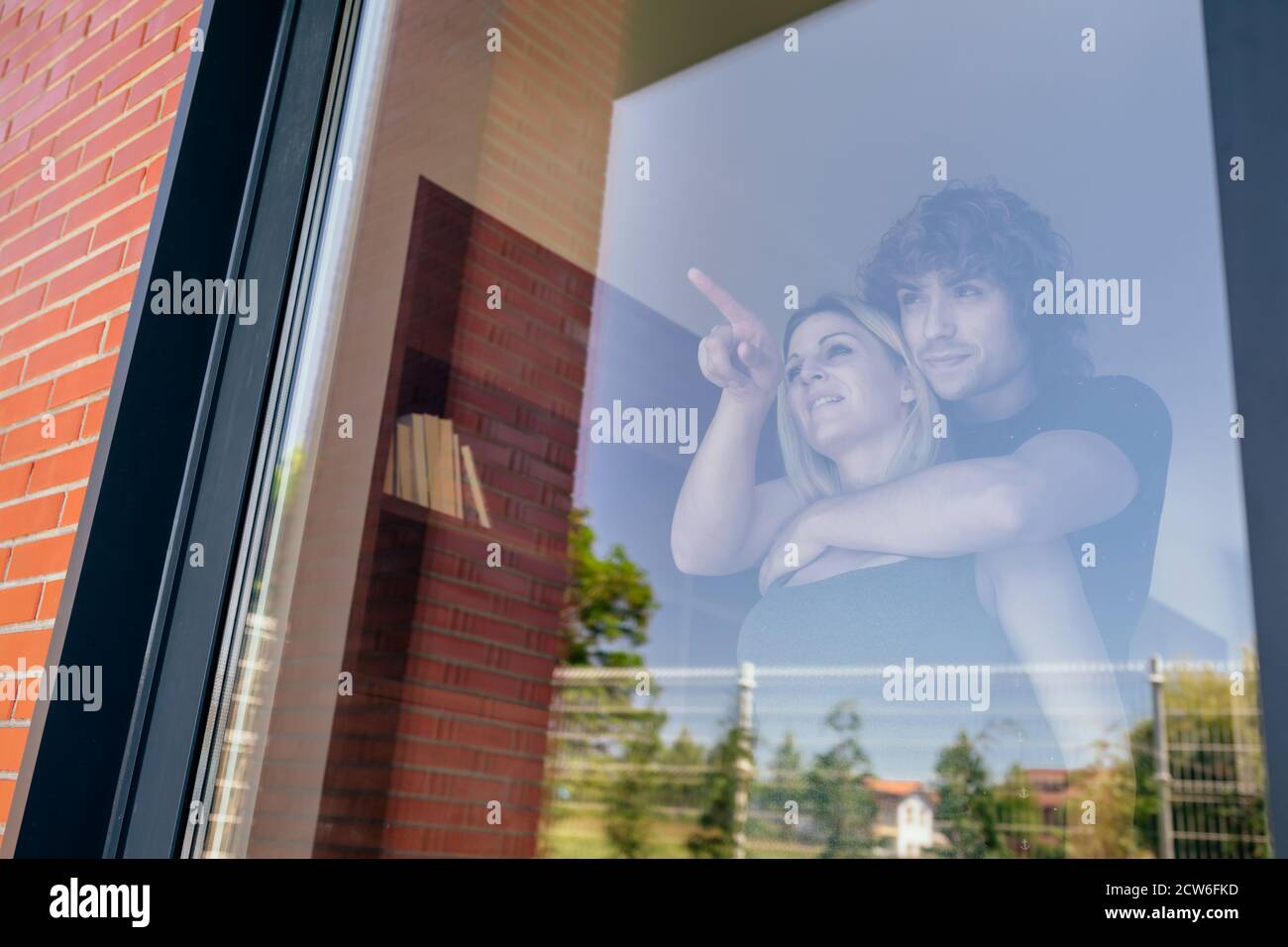 Couple looking at the garden through the window Stock Photo