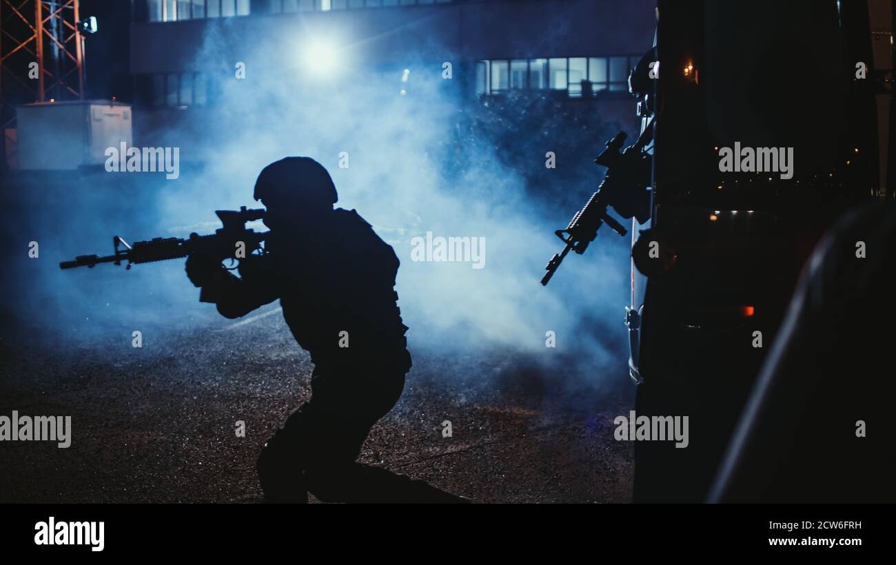 Silhouette of Masked Team of Armed SWAT Police Officers Exit a Black Van Parked Outside of an Office Building. Soldiers with Rifles and Flashlights Stock Photo
