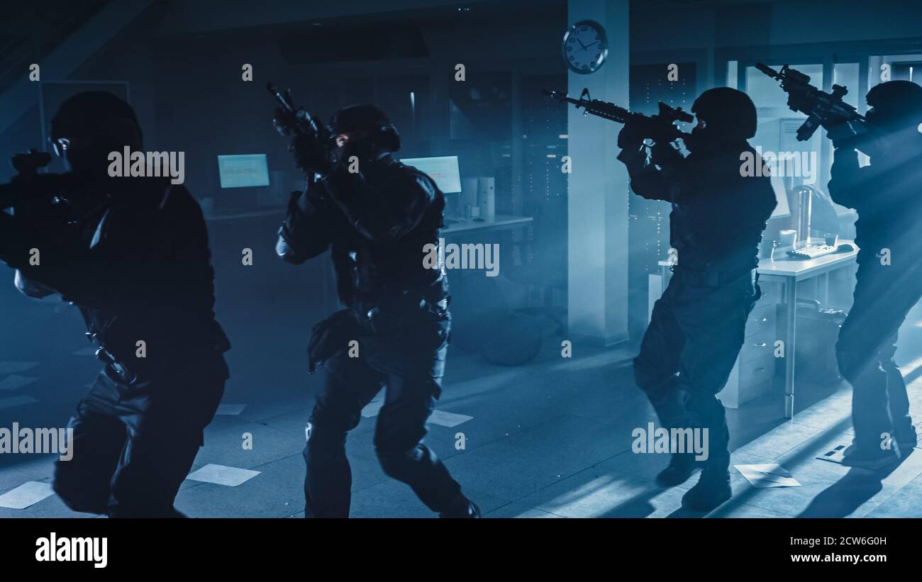 Masked Squad of Armed SWAT Police Officers Move in a Hall of a Dark ...