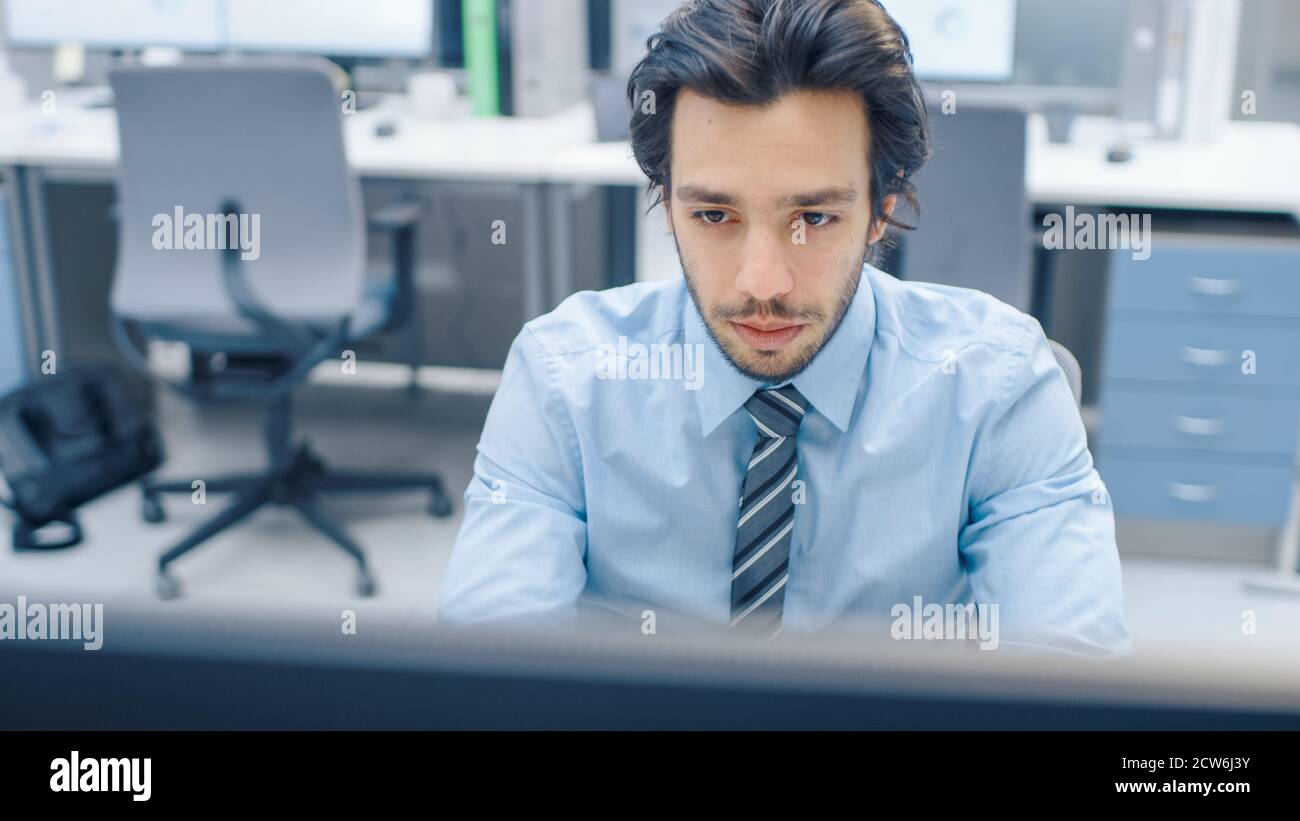 Handsome Motivated Office Worker Uses Desktop Computer, Typing on a