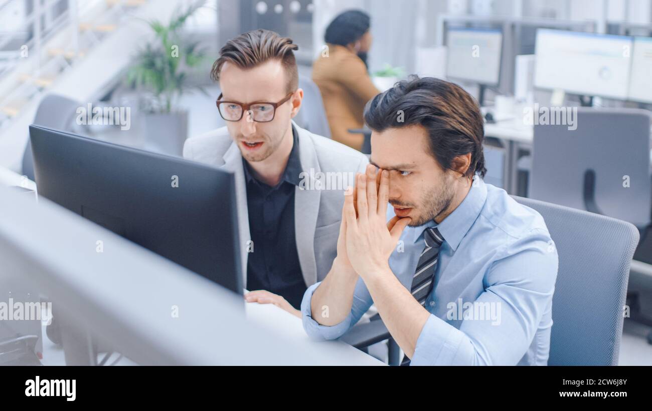 In Bright Modern Office: Handsome Office Worker Sitting and Working at ...