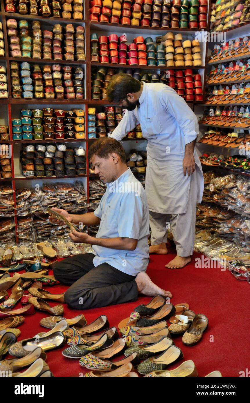 Shopkeepers tend to shoe shop selling hand made leather khussas Karachi Pakistan Stock Photo Alamy