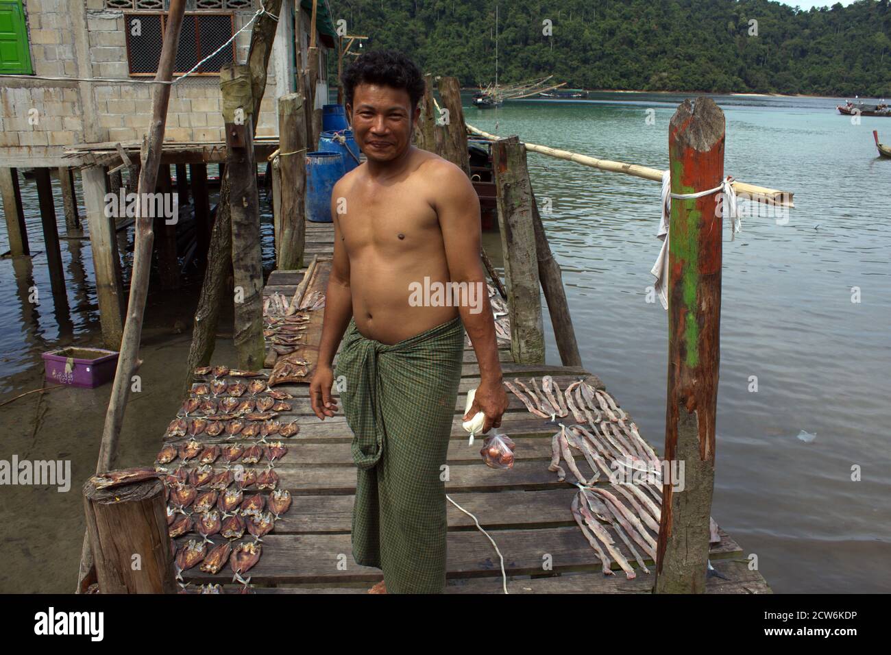 https://c8.alamy.com/comp/2CW6KDP/smiling-man-bare-chested-in-sarong-on-jetty-with-drying-fish-at-jalan-fishing-village-on-jalan-island-mergui-archipelago-myanmar-2CW6KDP.jpg