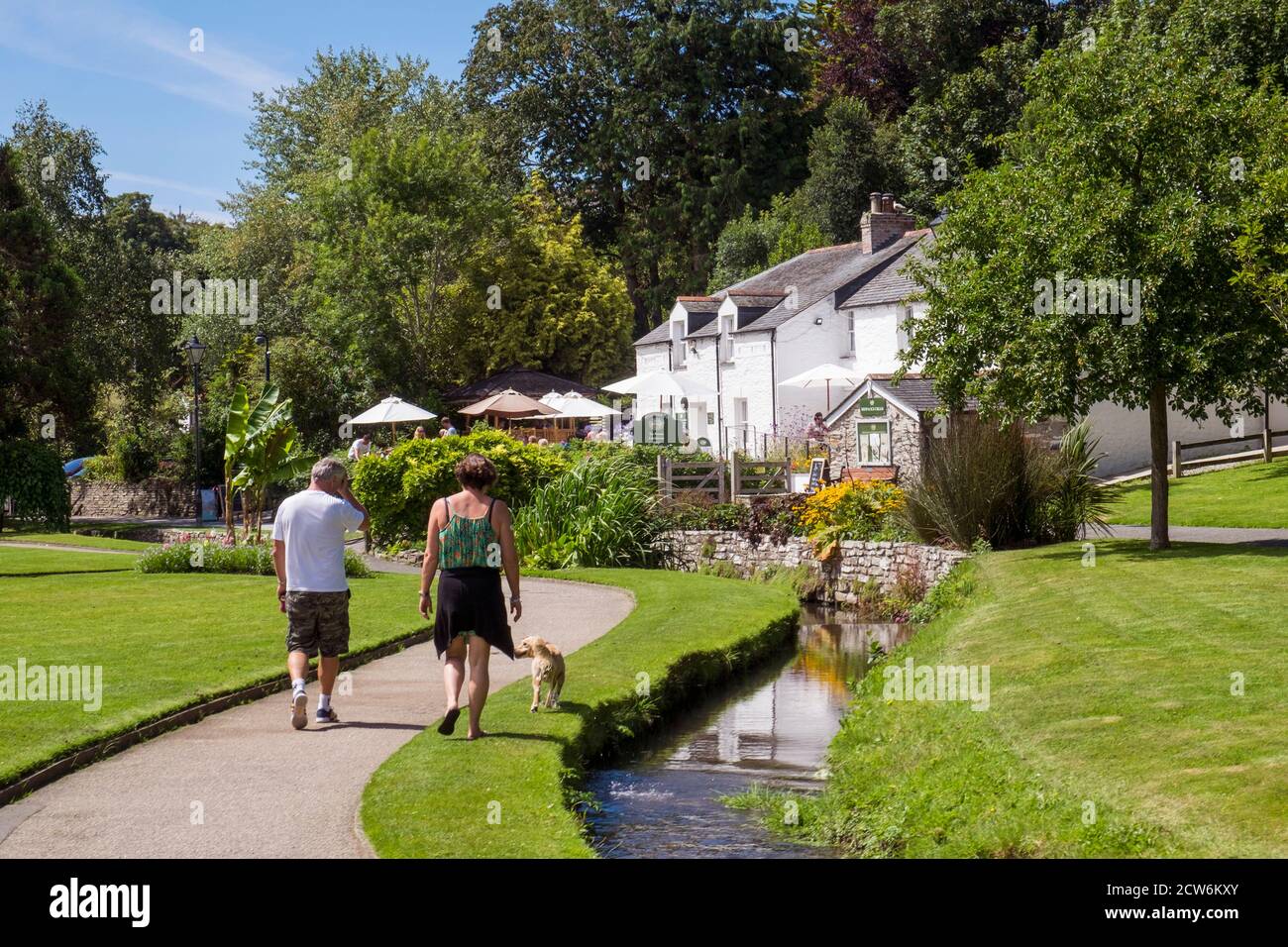 Tourists enjoying walking their dog in the landscaped Trenance Gardens in Newquay in Cornwall. Stock Photo