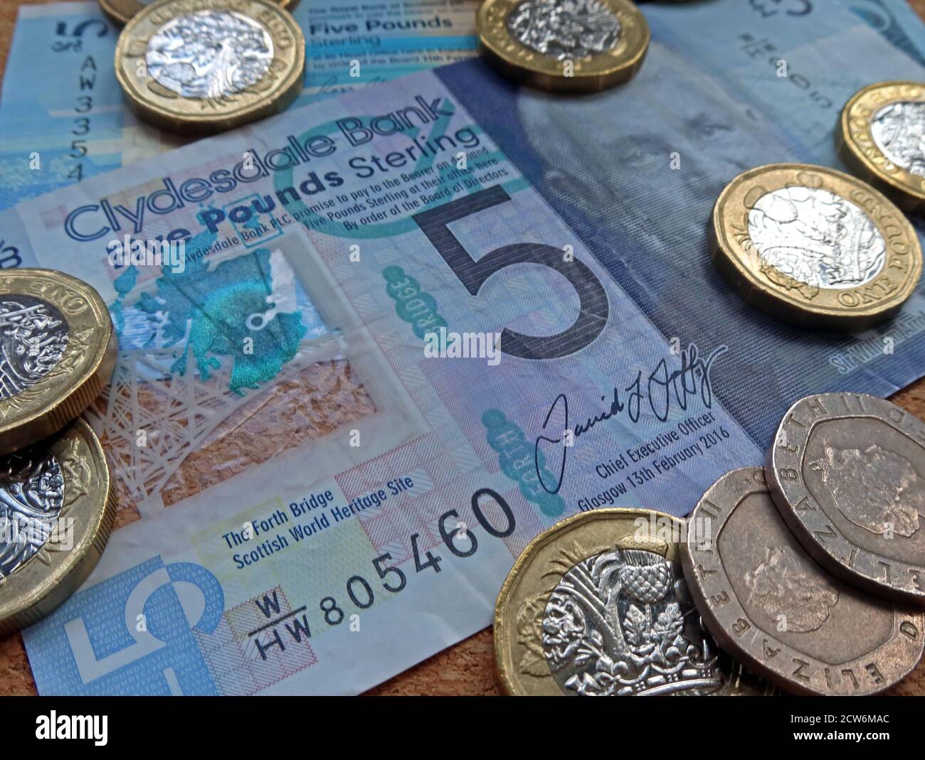 Clydesdale Bank five pound note, a fiver, with pound and twenty pence coins, Scottish Sterling currency Stock Photo