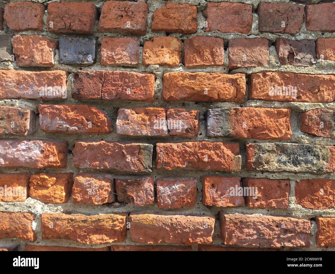 A full frame red brick wall background with worn and weathered bricks and grunge texture with copy space Stock Photo