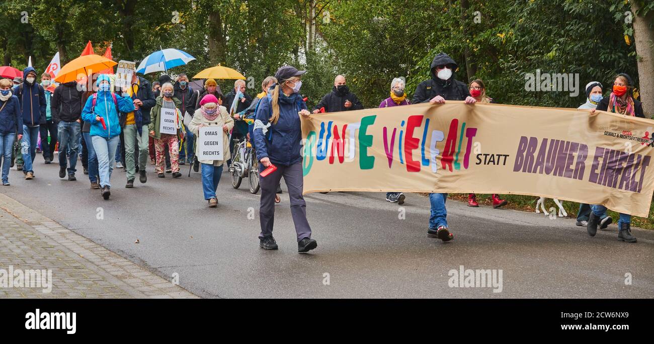 Eschede, Germany, September 26., 2020: Demonstration march of citizens on the country road towards a Nazi-occupied farm with a poster for multicultura Stock Photo