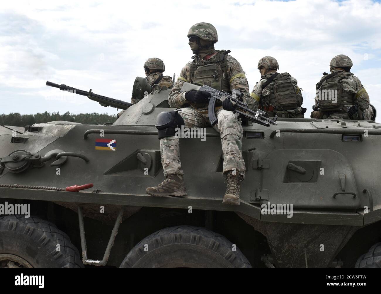 Flag of Flag of Artsakh and also known as Nagorno-Karabakh Republic on an armored personnel carrier and soldiers with machine guns. Collage. Stock Photo