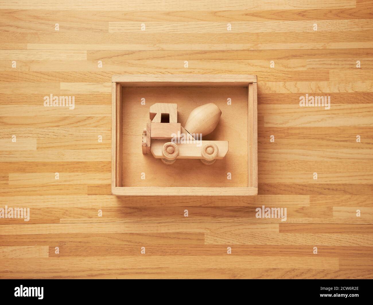 Wooden mixer truck toy inside a wooden box with a wooden texture background too Stock Photo